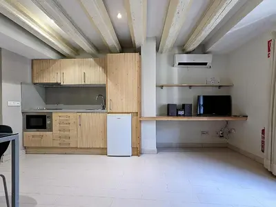 a kitchen with wooden cabinets and a white refrigerator at ClassBedroom Gothic Ramblas Apartments in Barcelona