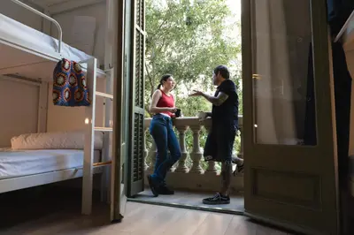 a man and a woman standing on a balcony in a room at The Central House Barcelona Gracia in Barcelona