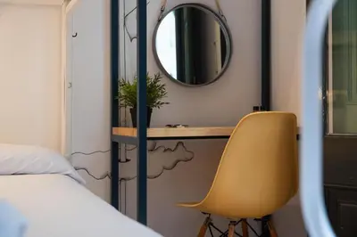 a bedroom with a mirror and a yellow chair at The Central House Barcelona Gracia in Barcelona