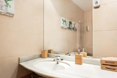 a white bathroom with a sink and a shower at El Alma de las Ramblas in Barcelona