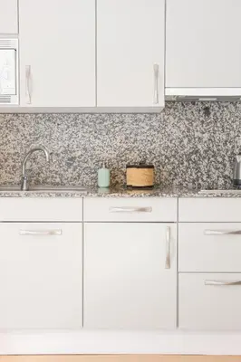 a white kitchen with white cabinets and a sink at El Alma de las Ramblas in Barcelona