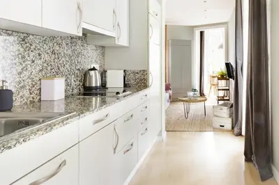 a kitchen with white cabinets and a dining room at El Alma de las Ramblas in Barcelona