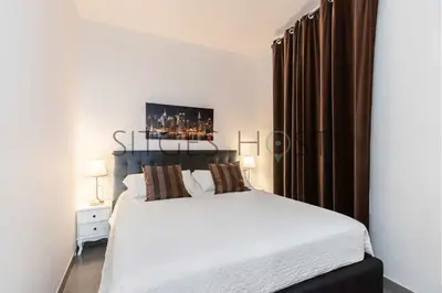a bedroom with a large white bed with brown curtains at Magnificas vistas al mar in Sitges