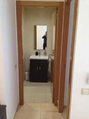 a man taking a picture of a bathroom with a mirror at Mejor Apartamento en Plaza España con Parking Gratuito in Barcelona
