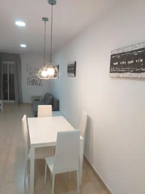a dining room with a white table and chairs at Mejor Apartamento en Plaza España con Parking Gratuito in Barcelona