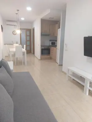 a living room and kitchen with a couch and a table at Mejor Apartamento en Plaza España con Parking Gratuito in Barcelona