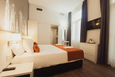 a hotel room with a bed and a desk at Hostal Live Barcelona in Barcelona