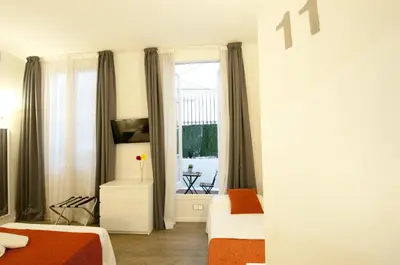 a bedroom with two beds and a window at Hostal Live Barcelona in Barcelona