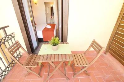 a balcony with a table and two chairs and a potted plant at Hostal Live Barcelona in Barcelona