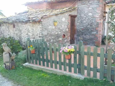 a wooden fence in front of a house with flowers at Ca L'Estrada in Sant Esteve de Palautordera