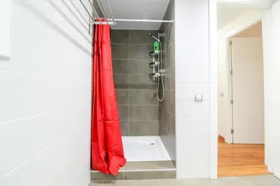 a shower with a red shower curtain in a bathroom at Girona 108 in Barcelona