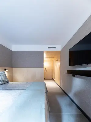a bedroom with a bed and a flat screen tv at Hotel Raval House in Barcelona