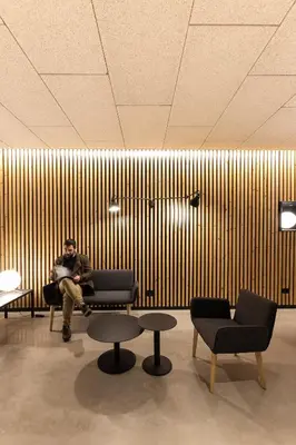 a man sitting on a bench in front of a wooden wall at Hotel Raval House in Barcelona