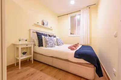 a small bedroom with a bed and a window at RamblasRentals Chic & Spacious Flat Pool Table 15M Ramblas - Parking - Wifi in Barcelona