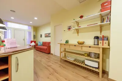 a kitchen and living room with a red couch at RamblasRentals Chic & Spacious Flat Pool Table 15M Ramblas - Parking - Wifi in Barcelona