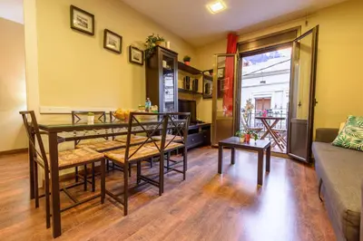 a living room with a table and a couch at RamblasRentals Cozy Renovated 2BR with Balcony Lift 20M Rambla - Parking - Wifi in Barcelona