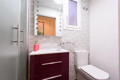 a bathroom with a toilet and a sink and a mirror at RamblasRentals Cozy Renovated 2BR with Balcony Lift 20M Rambla - Parking - Wifi in Barcelona