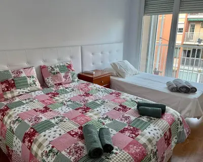 a bedroom with a bed with a quilt on it at Amplio Apartamento cerca de FIRA y del Centro in Hospitalet de Llobregat