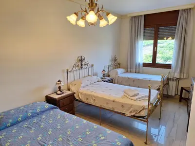a bedroom with two beds and a chandelier at Cal Llopet in Can Cartro