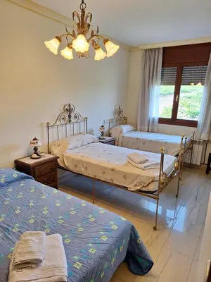 a bedroom with two beds and a chandelier at Cal Llopet in Can Cartro