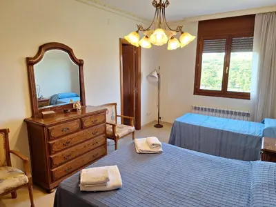 a bedroom with two beds and a dresser and a mirror at Cal Llopet in Can Cartro