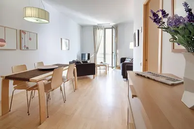 a dining room and living room with a table and chairs at Habitat Apartments Alibei in Barcelona