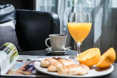 a plate of food and a glass of orange juice at Habitat Apartments Alibei in Barcelona