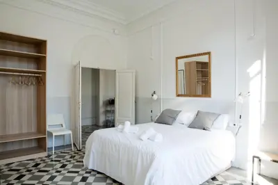 a white bedroom with a white bed and a mirror at My Address in Barcelona in Barcelona