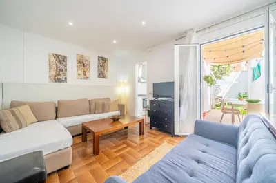 a living room with a couch and a tv at HomeHolidaysRentals Arlene in Calella