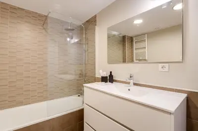 a bathroom with a sink and a mirror and a tub at Sweett - Verdi in Barcelona