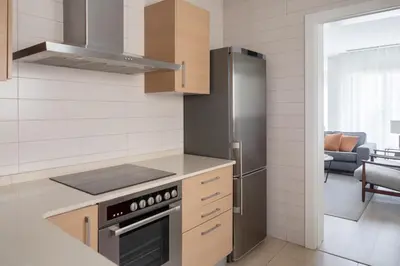 a kitchen with a stainless steel refrigerator and cabinets at Murmuri Residence Concepció in Barcelona