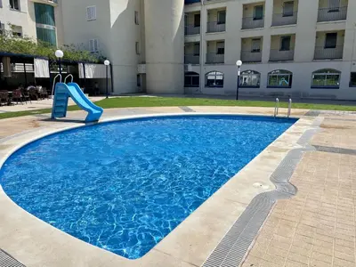a swimming pool with a slide in front of a building at La Marina SeaView Penthouse in Sitges