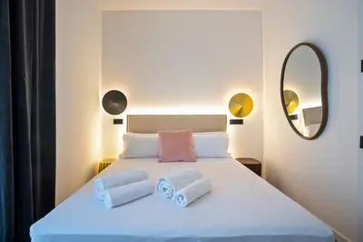 a bedroom with a bed with two pillows and a mirror at Hotel Casa Trafalgar Barcelona in Barcelona