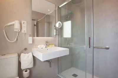 a bathroom with a sink and a shower and a toilet at Hotel Casa Trafalgar Barcelona in Barcelona