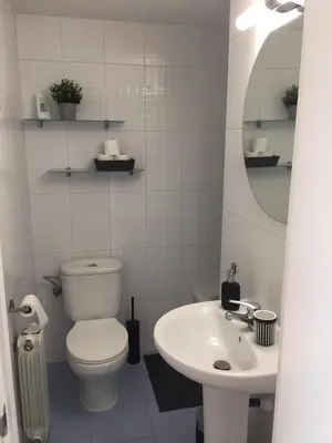 a white bathroom with a toilet and a sink at Luxury Apartment Accommodation, next to beach & train station Calella in Calella