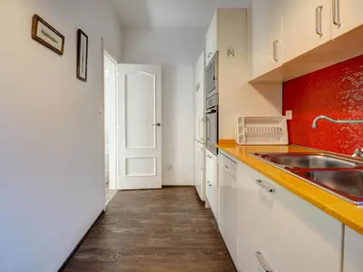 a kitchen with white cabinets and a sink at The Lilium Apartment by Hello Homes Sitges in Sitges