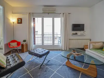 a living room with a couch and a glass table at The Lilium Apartment by Hello Homes Sitges in Sitges