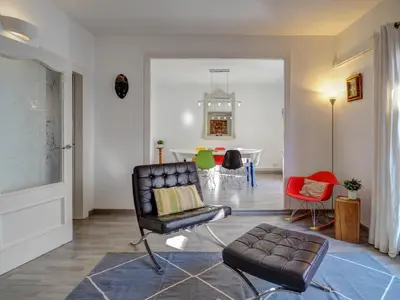 a living room with a chair and a table at The Lilium Apartment by Hello Homes Sitges in Sitges
