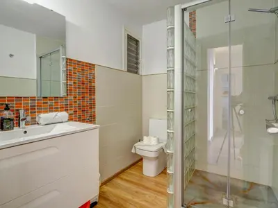 a bathroom with a toilet and a glass shower at The Lilium Apartment by Hello Homes Sitges in Sitges