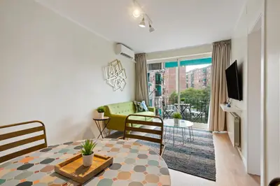 a living room with a dining table and a living room with a couch at Tendency Apartments Forum 4 in Sant Adria de Besos
