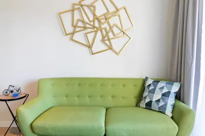 a green couch sitting in a living room with a wall at Tendency Apartments Forum 4 in Sant Adria de Besos