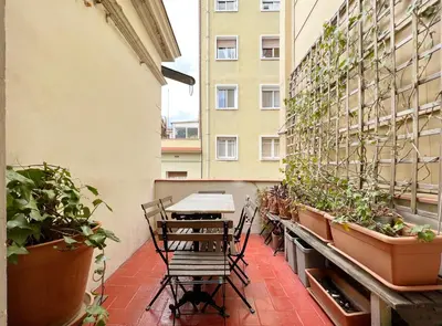 a balcony with a table and chairs and potted plants at Stay U-nique Apartments Legalitat in Barcelona