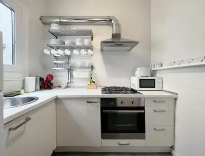 a white kitchen with a stove and a microwave at Stay U-nique Apartments Legalitat in Barcelona