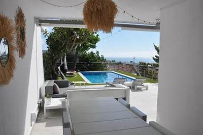 a patio with a swimming pool and a table and chairs at Miramar Sitges in Sitges