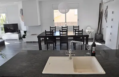 a kitchen and dining room with a sink and a table at Miramar Sitges in Sitges