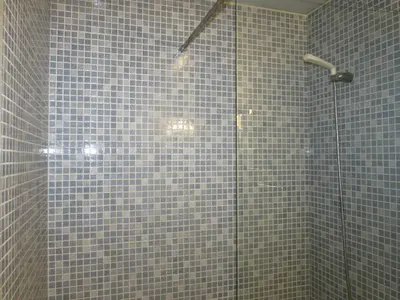 a bathroom with a shower with blue tiles at Pensió Cerdanya in Barcelona