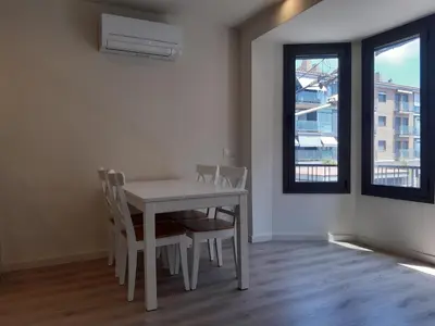 a white dining room with a table and chairs at Calella Playa Vistas Mar in Calella