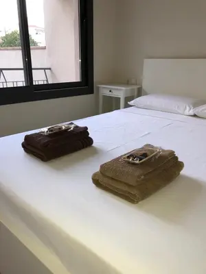 two towels are sitting on a white bed at Calella Playa Vistas Mar in Calella