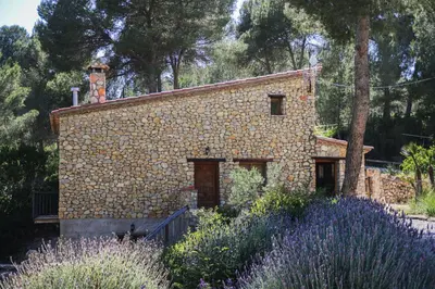 a stone house with a chimney on top of it at Masia Pou de la Vinya in Sitges