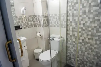 a small bathroom with a toilet and a shower at Hostal Restaurante Avenida de Madrid in Terrassa